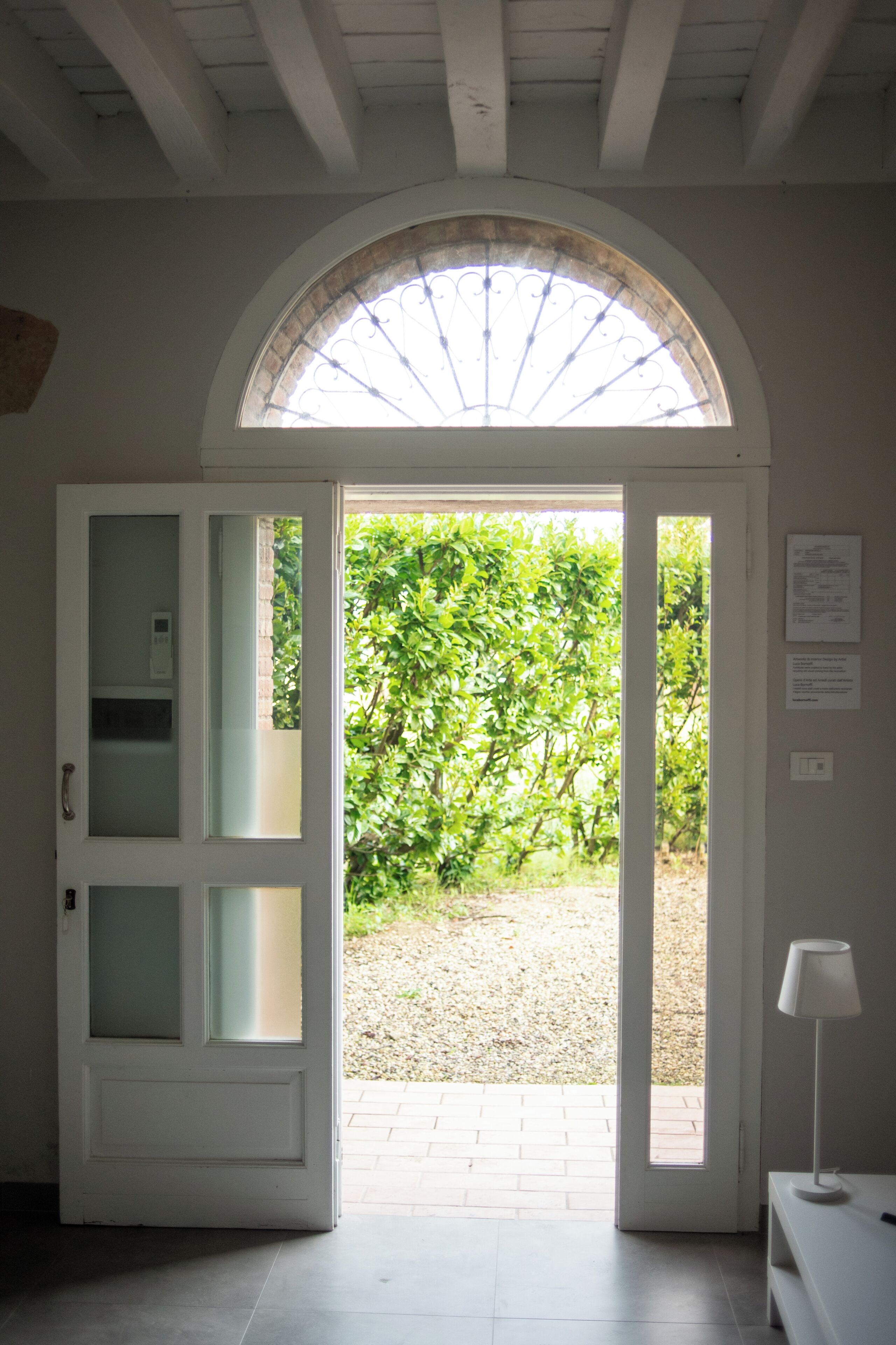 A doorway leading to an outdoor area with a view of greenery.