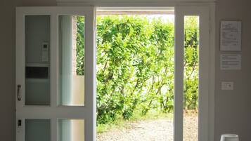 A doorway leading to an outdoor area with a view of greenery.