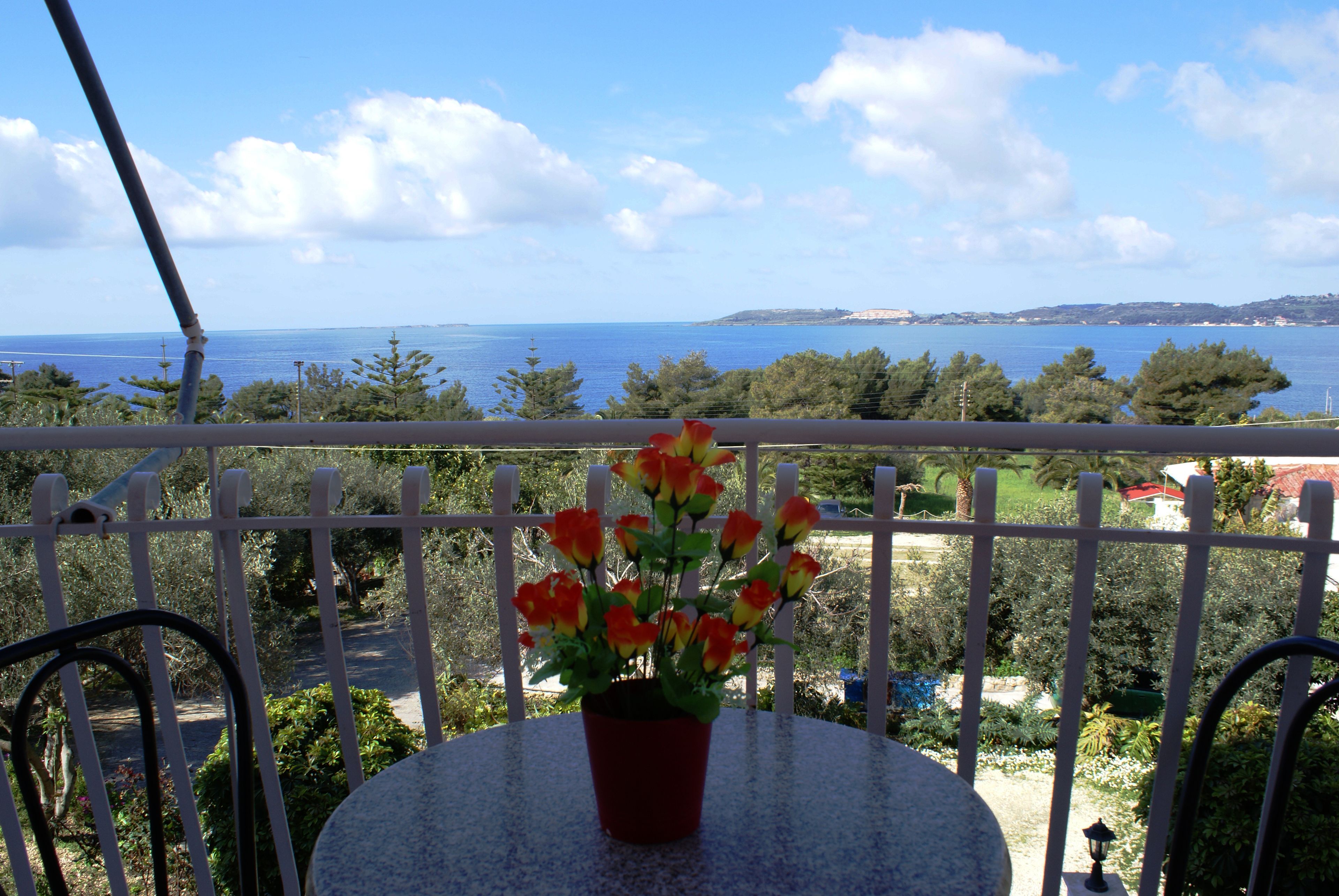 Ein Balkon mit einem Blumentopf und Meerblick.