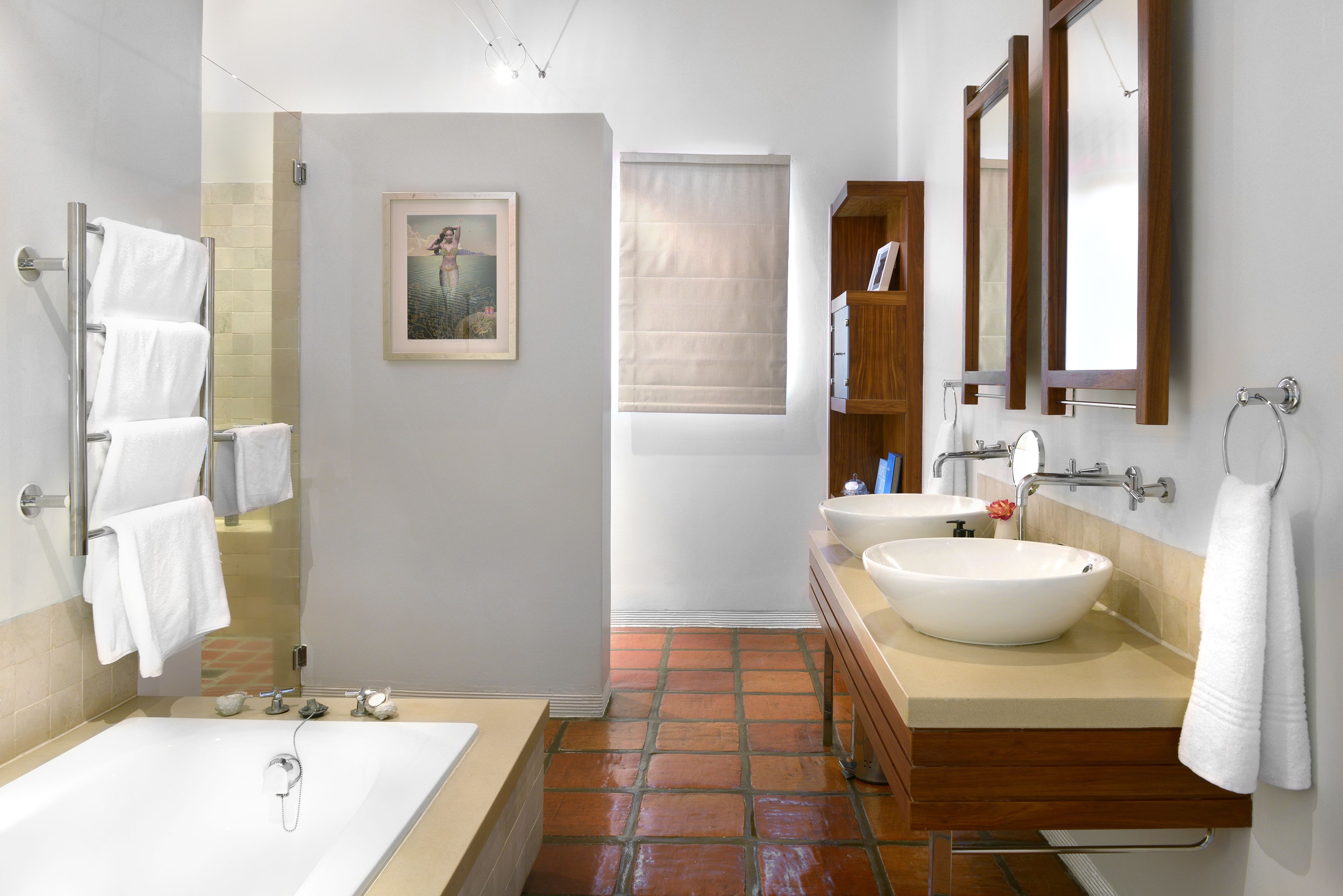 Un baño moderno con bañera, dos lavamanos y ducha.