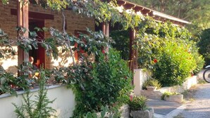 Ein Ziegelhaus mit Veranda und Garten.