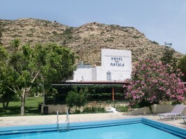Una piscina al aire libre de temporada, sombrillas