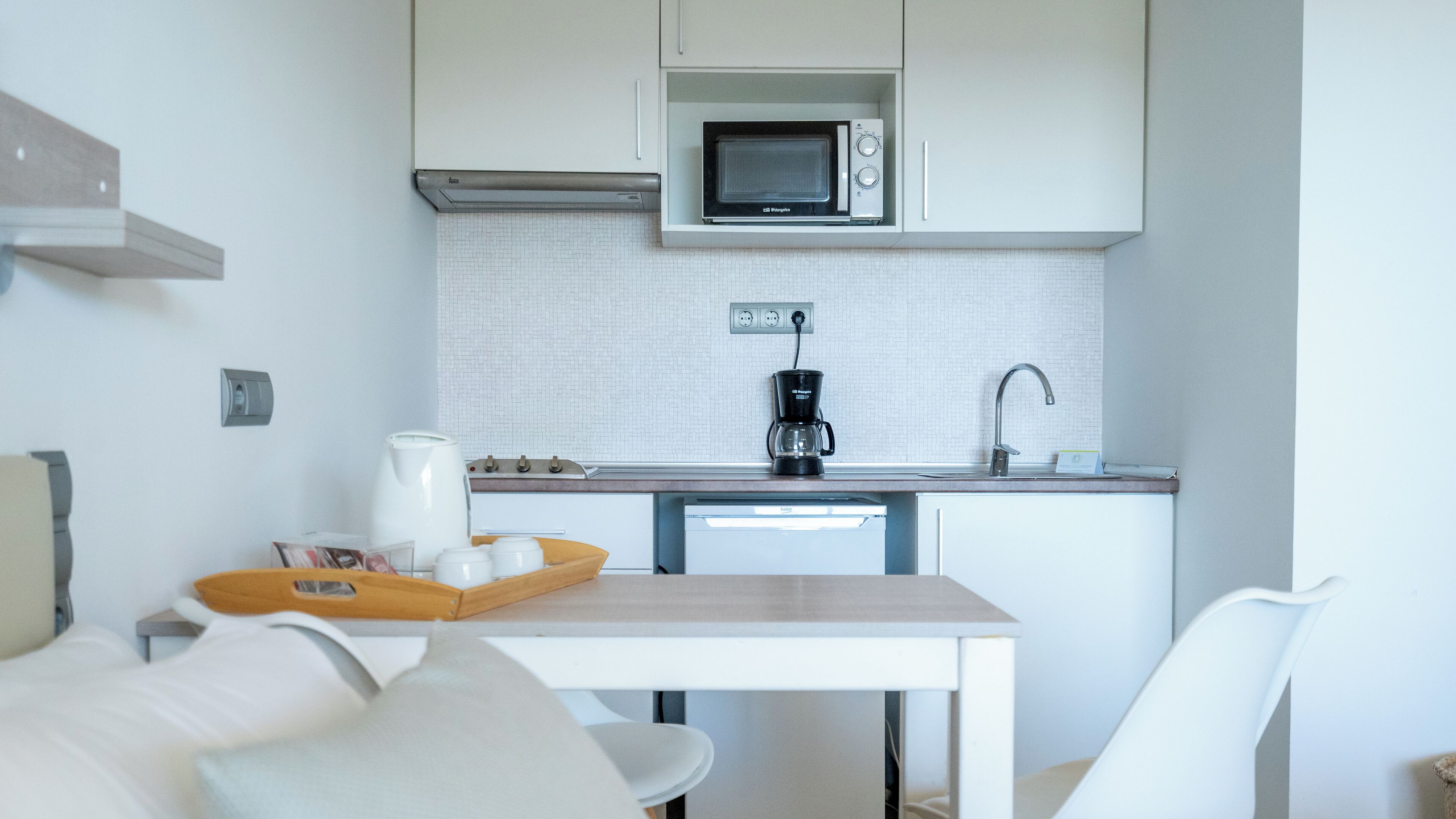 Una cocina compacta equipada con microondas, cafetera y lavavajillas.
