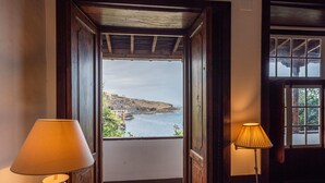 A wooden door leading to a balcony with a view of a coastal landscape. - Isla Baja Suites (Garachico)