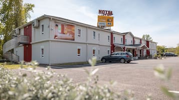 Een hotel met een groot bord waarop originele toegang en een prijs van 46 euro staan aangegeven.