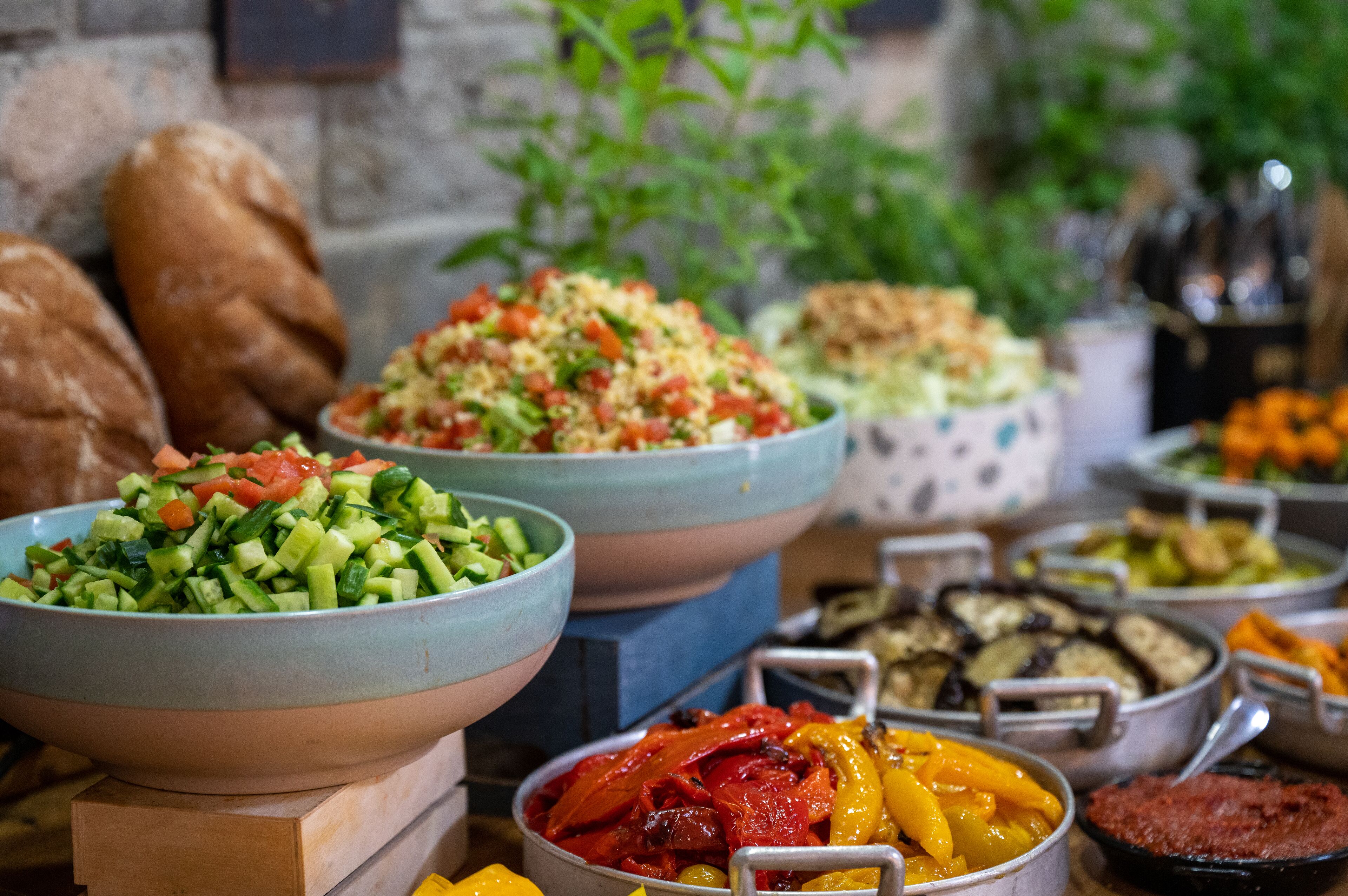 A variety of food dishes displayed in bowls and containers, suggesting a buffet setting.