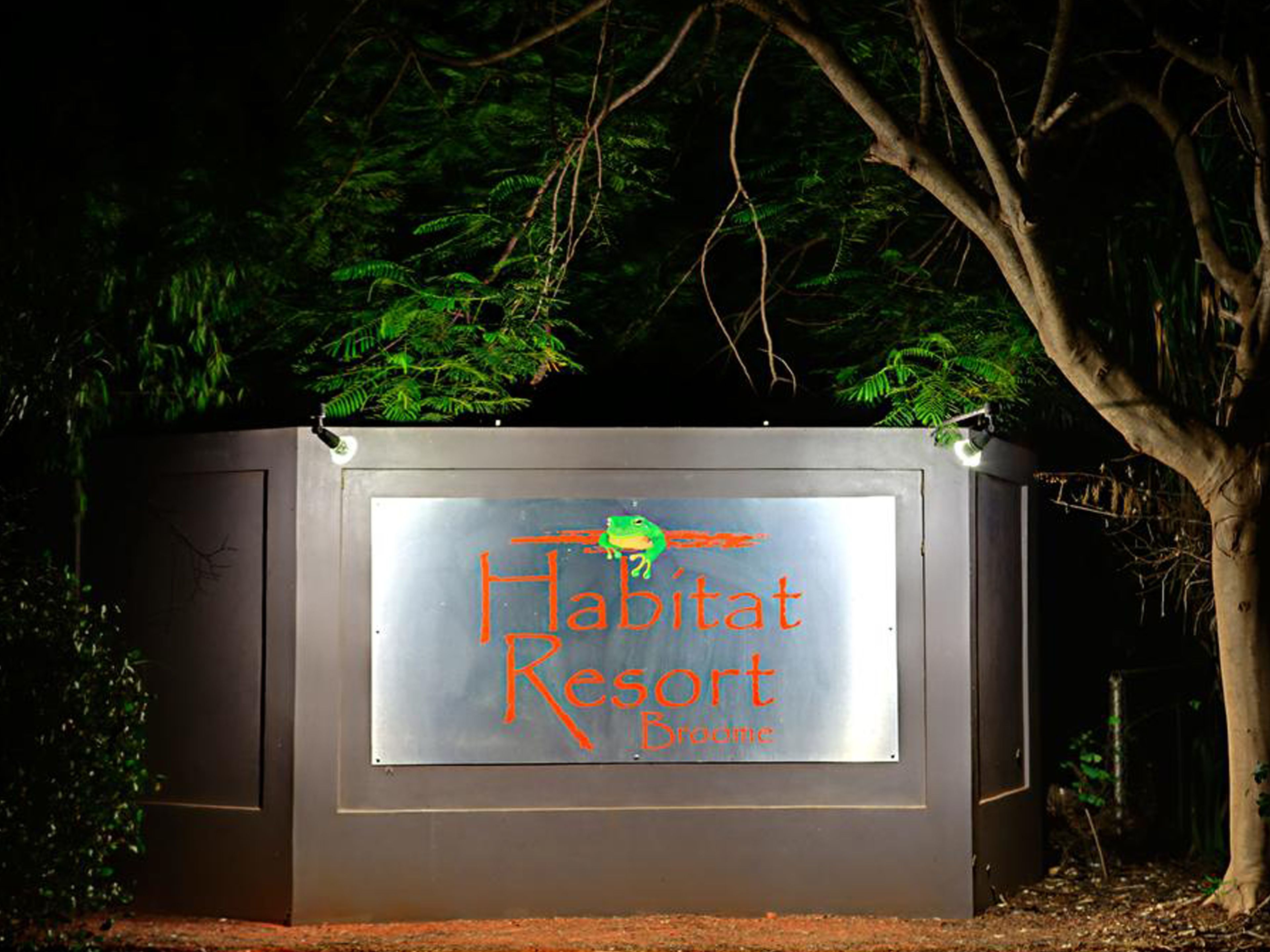 A sign for Habitat Resort with a logo and name.