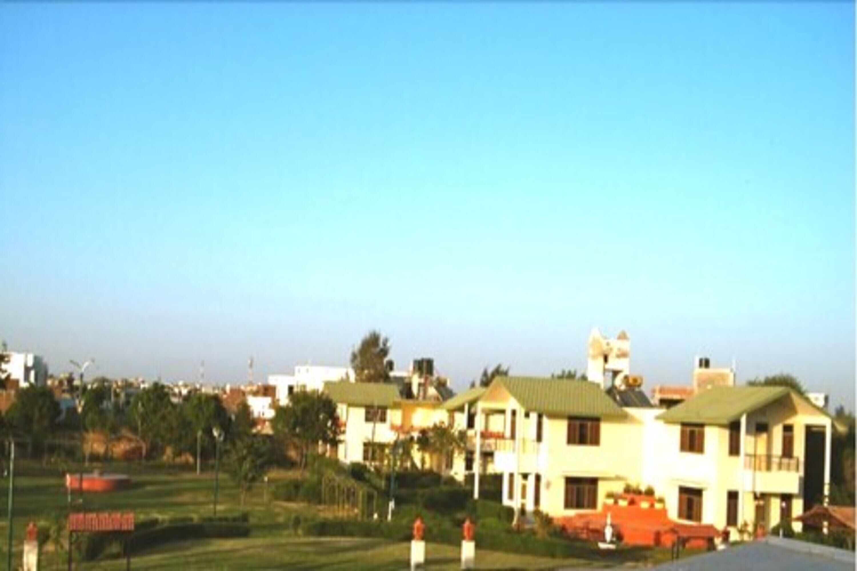 A row of two-story buildings with flat roofs, likely residential or hotel buildings, set against a clear sky.