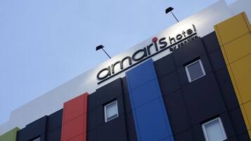 A hotel sign with the name 'Amaris Hotel' and 'By Santino' on a multi-colored facade.