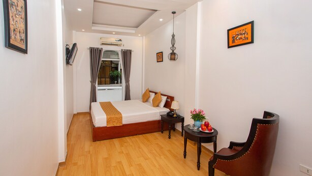 A hotel room with a bed, a desk, a chair, and a window with curtains. - Rendez Vous Hotel (Hanoi)