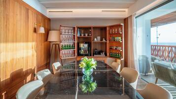 Een vergaderruimte met een marmeren tafel, stoelen, een koffieapparaat en een minibar.