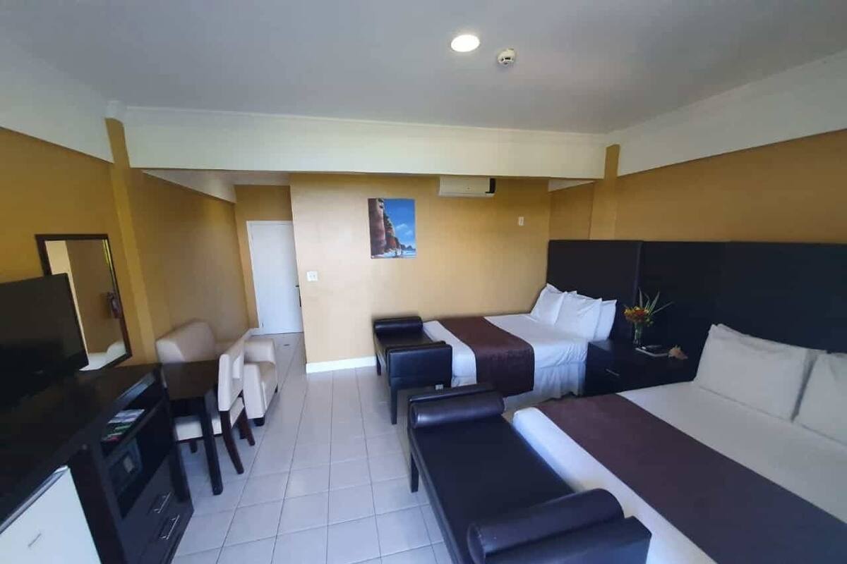 Una habitación de hotel con cama, escritorio, televisor y zona de estar.