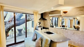 A modern kitchen with a built-in island, large windows, and a cozy seating area with a sofa and cushions.