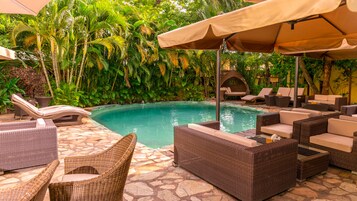 Una piscina al aire libre, sombrillas, tumbonas