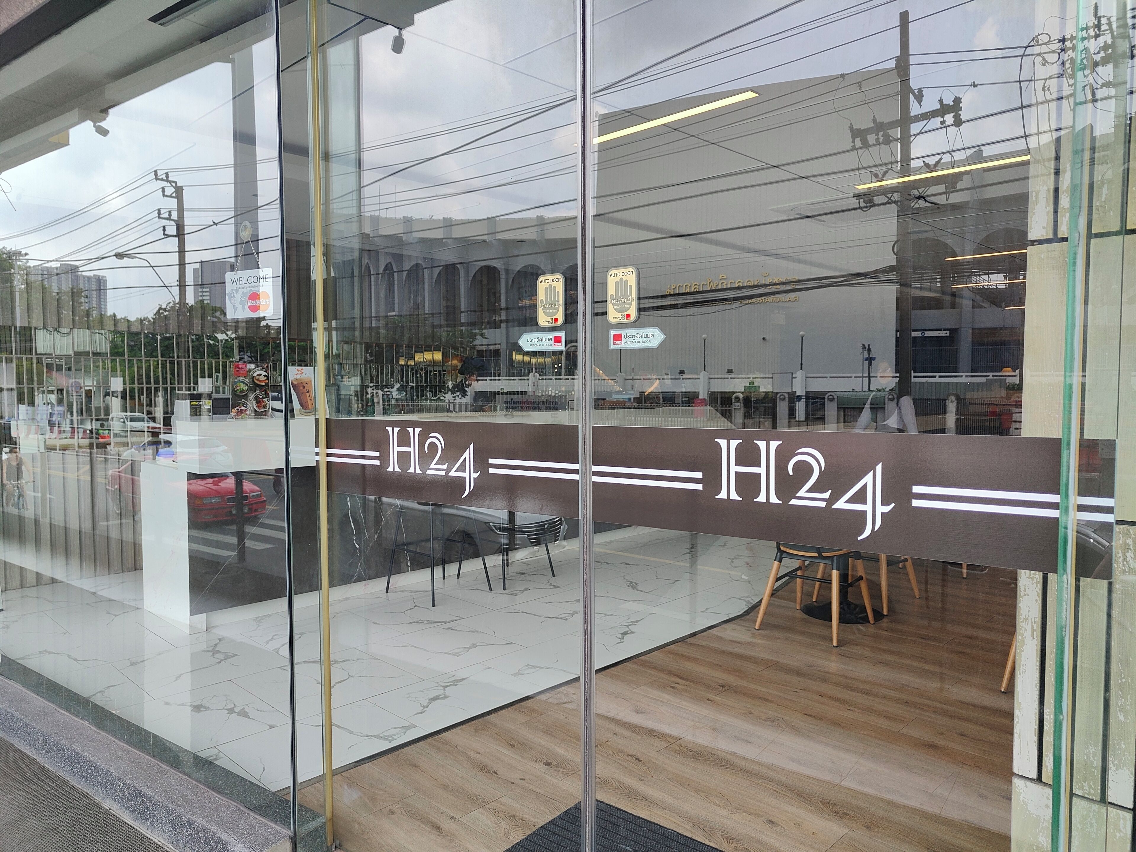 A modern interior with a glass partition displaying the name "H2A".