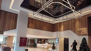 A spacious lobby with a modern chandelier, a Christmas tree, and a sign for 'Bangkok Inter Place'. - Bangkok Inter Place Hotel (Bangkok)