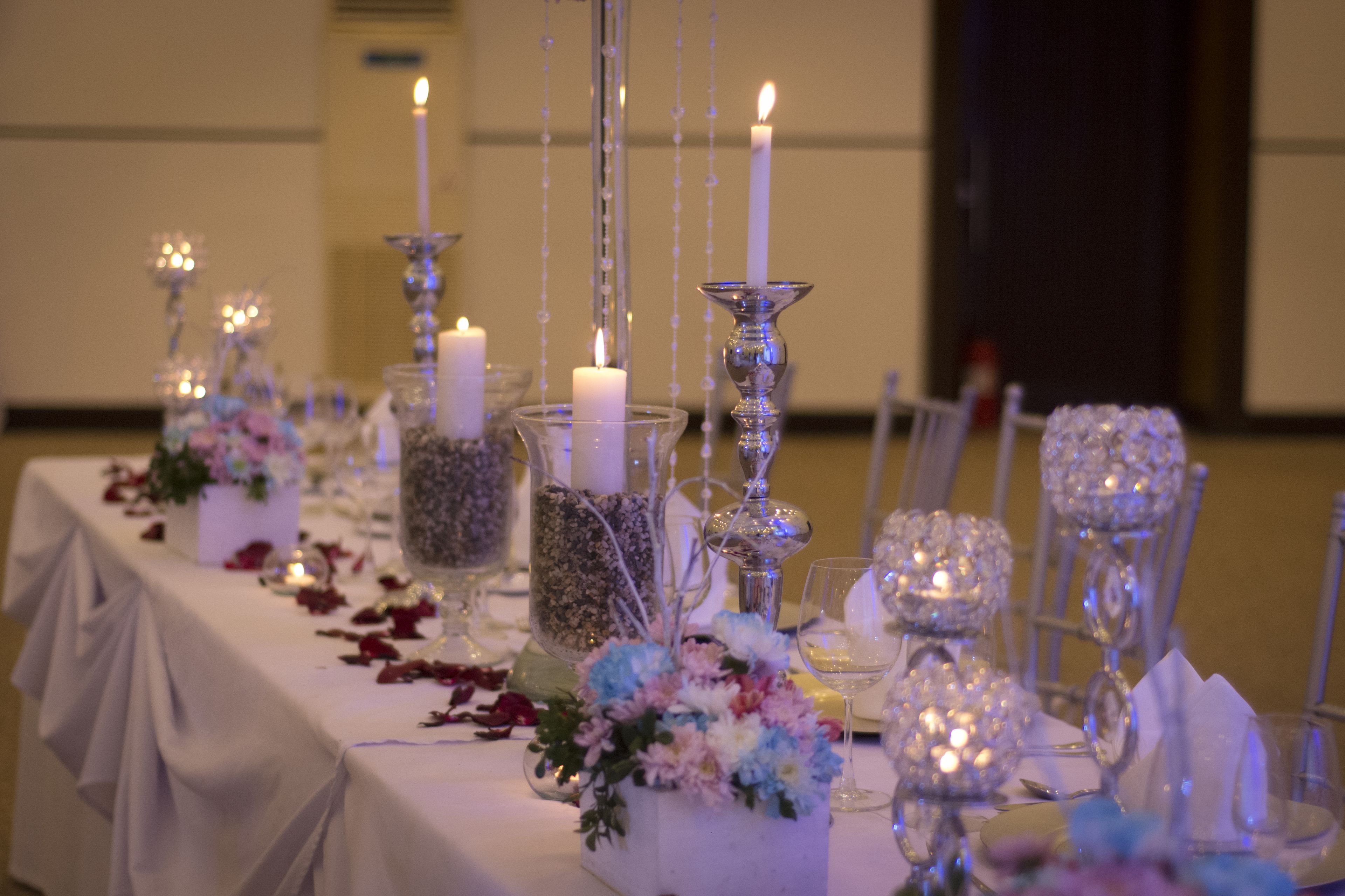 A table set with candles, glassware, and floral centerpieces.