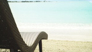 A beach chair facing a calm sea with gentle waves. - Canyon Cove Hotel & Spa (Nasugbu)