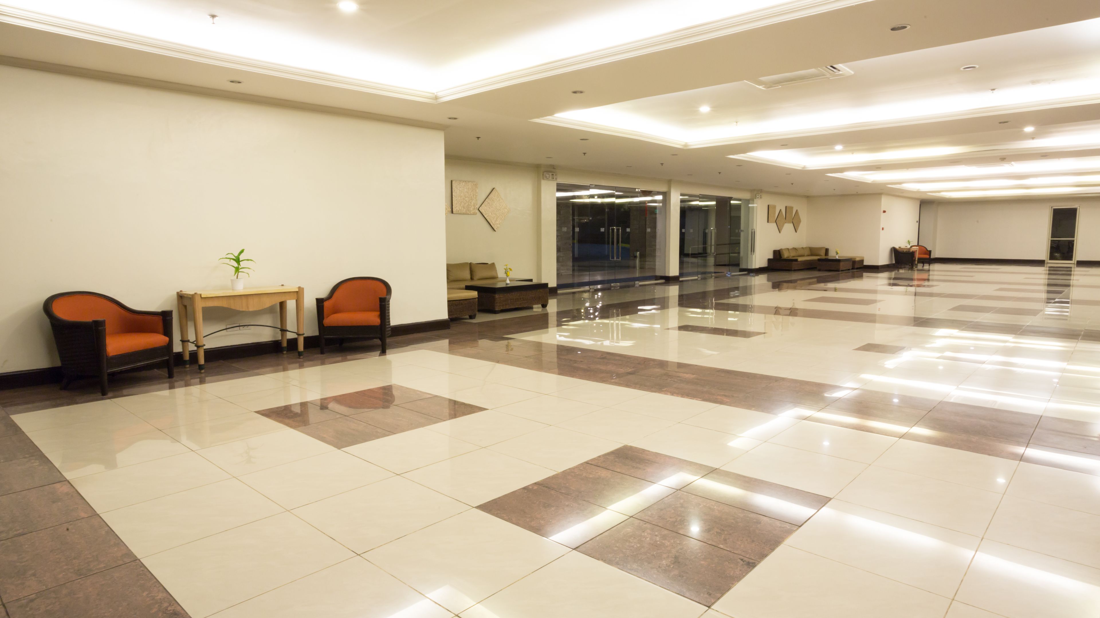 A spacious lobby with a polished tile floor, a reception desk, and seating areas.