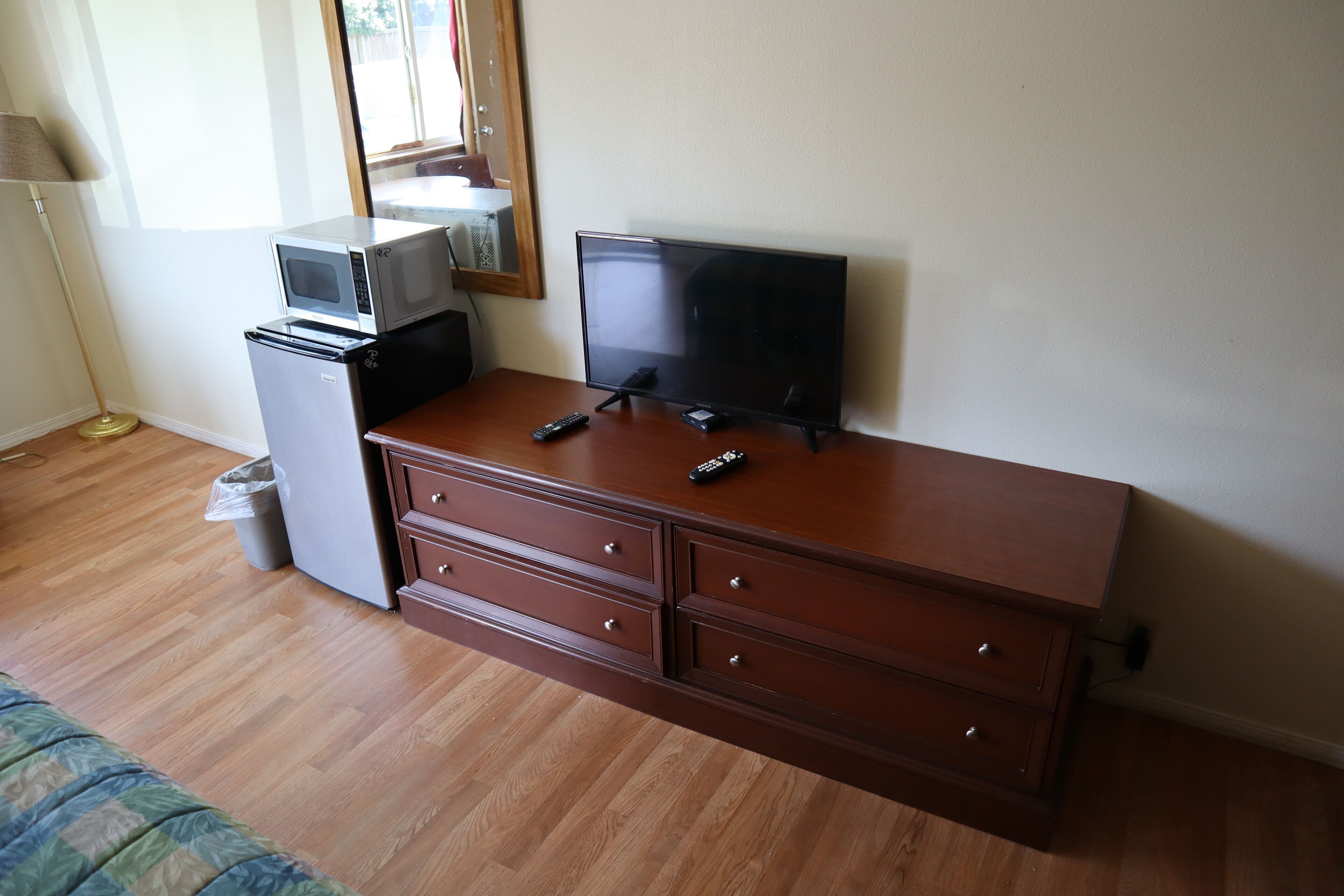 Un aparador de madera con un televisor de pantalla plana, un microondas y un refrigerador.