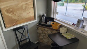 Un pequeño espacio de oficina con un escritorio, una silla y un tablón de anuncios.