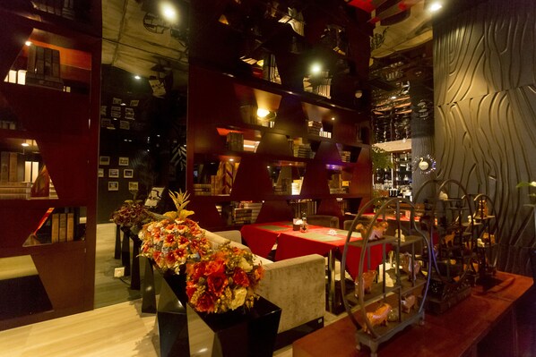 Un restaurant avec des nappes rouges, de nombreuses tables et des chaises.