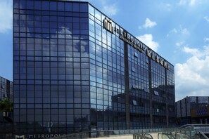 A modern glass building with the name "Metropole Jinyang Hotels" on the facade. - Metropolo Guangzhou Wanda Plaza Hotel (Guangzhou)
