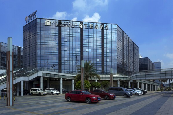 A modern hotel with a glass facade, multiple parking spaces, and a covered entrance. - Metropolo Guangzhou Wanda Plaza Hotel (Guangzhou)