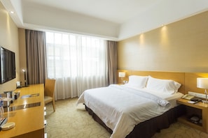 A hotel room with a large bed, a desk with a chair, a TV, and a window with curtains. - Metropolo Guangzhou Wanda Plaza Hotel (Guangzhou)