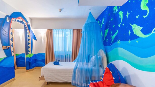 A room with a bed, a canopy, and a mural of sea creatures. - Kuta Beach Hotel (Kuta)