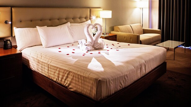 A hotel room with a large bed, a bedside table with a lamp, a chair, and a small table. - DoubleTree by Hilton Lincoln (Lincoln)
