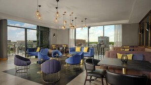 A modern lounge area with seating, a dining table, and pendant lighting. - DoubleTree by Hilton Lincoln (Lincoln)