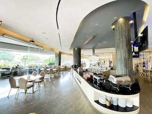 A modern hotel lobby with a curved reception desk, seating area, and a buffet. - 89 Hotel (Batam)