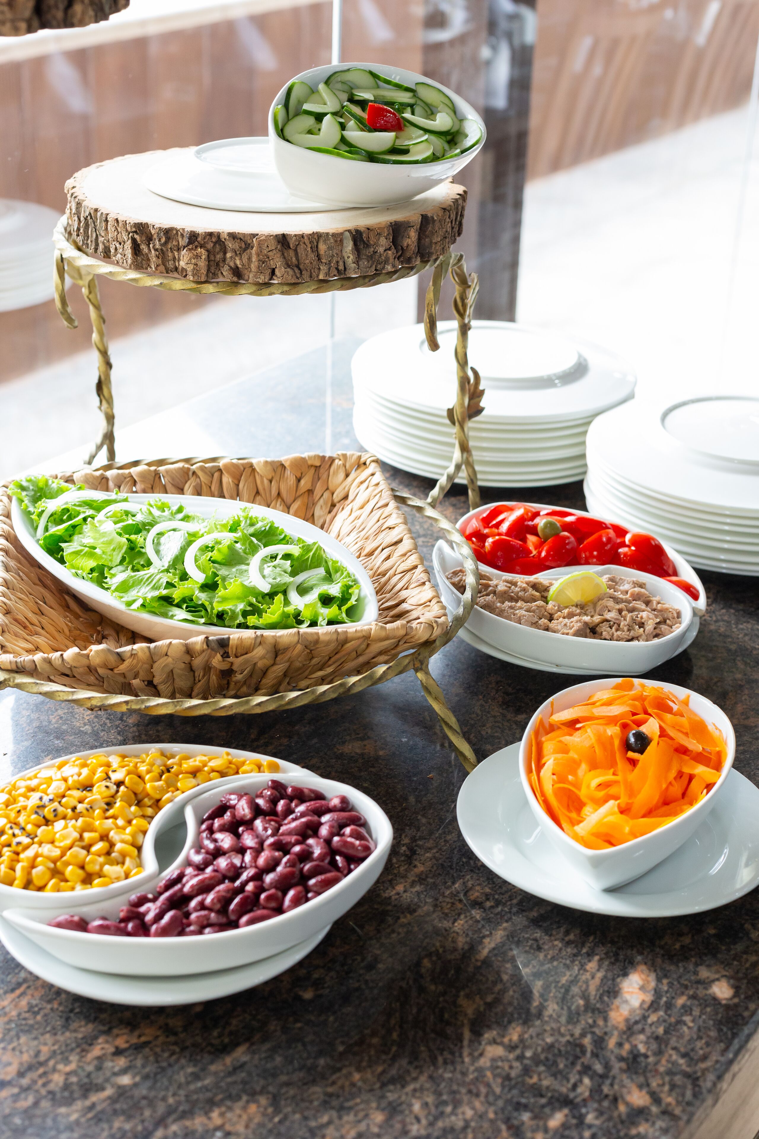 A buffet table with various dishes including salads, beans, and vegetables.