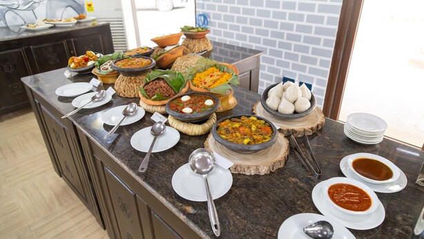 A buffet with various dishes and utensils. - Sunlodge Hotel (Accra)