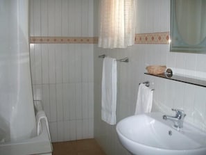 A bathroom with a white sink, a mirror, a shower curtain, and a towel rack. - Rayporsh Hotel (Accra)
