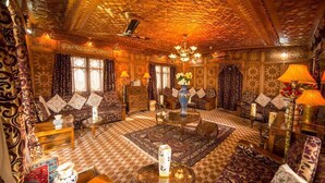 A richly decorated living room with patterned carpets, ornate furniture, and a central coffee table. - Swan Group Of Houseboats (Srinagar)