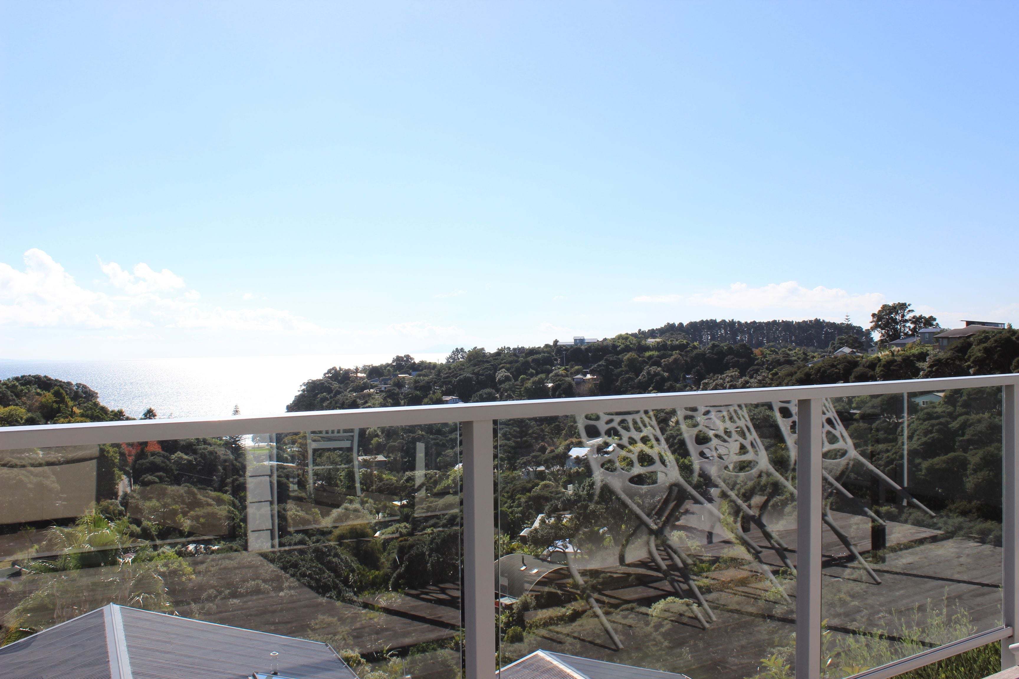 A modern building with a glass facade overlooking a coastal area.