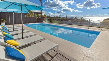 Piscine extérieure, parasols de plage, chaises longues