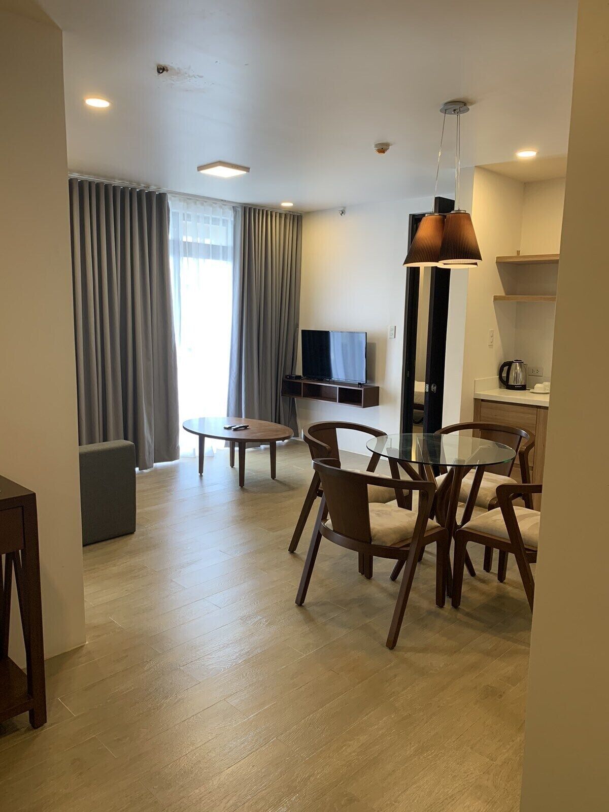 Una sala moderna con comedor, televisor de pantalla plana y cafetera.