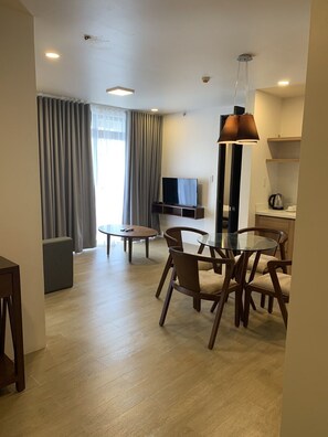 A modern living room with a dining area, a flat-screen TV, and a coffee maker. - Canyon Woods Resort Club (Laurel)