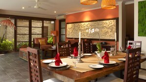 Comedor con una mesa de madera dispuesta para cuatro personas, rodeada de sillas.