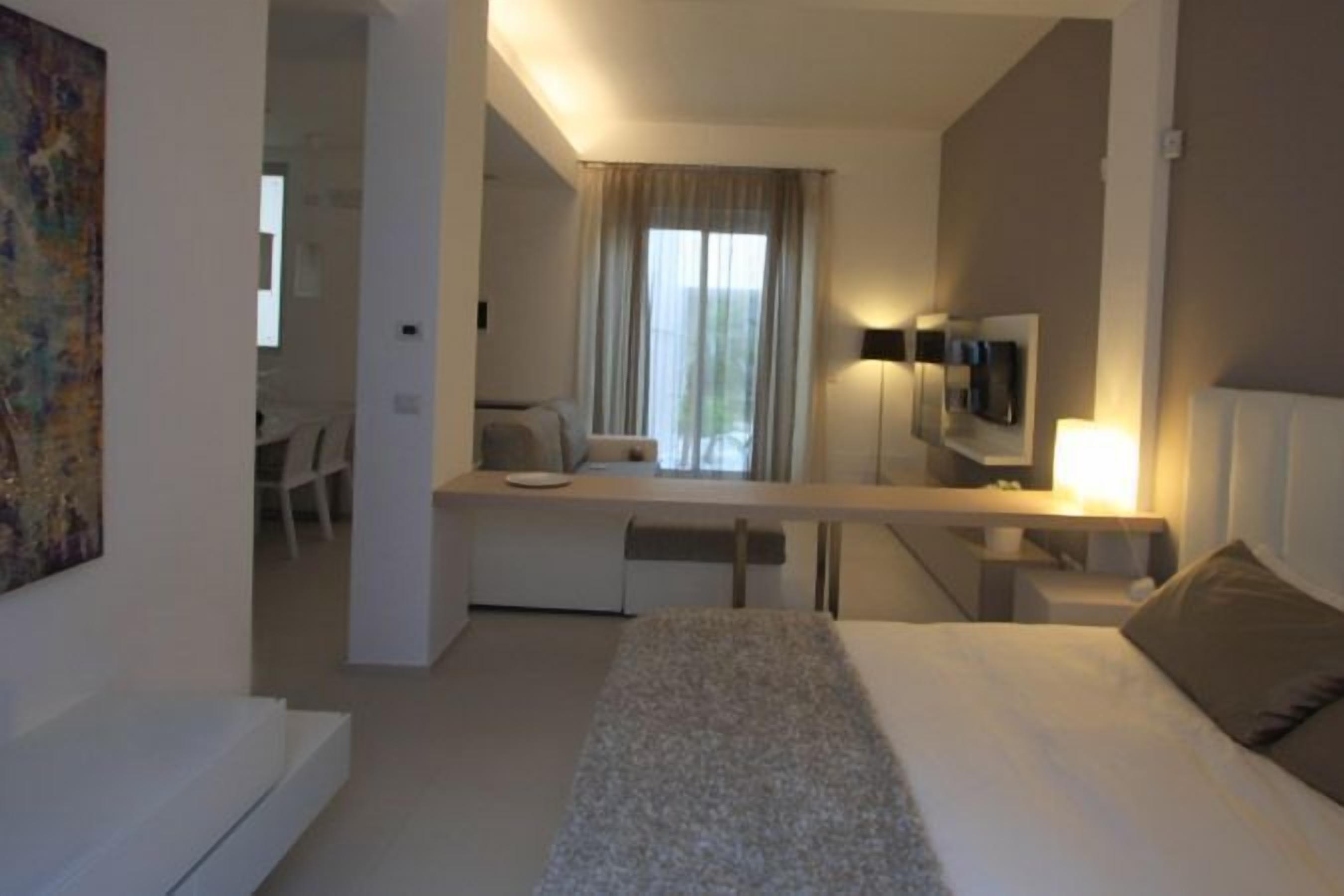 Quarto de hotel moderno com cama, escrivaninha e cadeira.