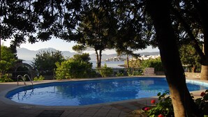 A swimming pool with a view of a city and mountains in the background. - Lato Hotel (Agios Nikolaos)