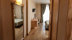 A hotel room with a bed, a desk, a chair, a television, and a mirror. - Boutique Hotel Il Riccio (Roccaraso)