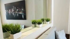 Un soggiorno moderno con un divano, un tavolino da caffè e piante in vaso.