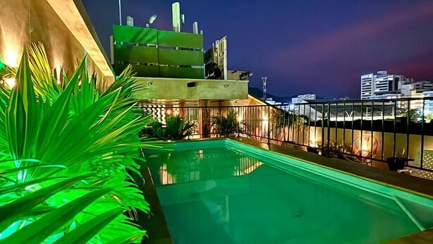 Una piscina sul tetto con vista sullo skyline della città al crepuscolo.