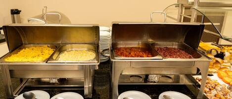 Servicio de comidas tipo buffet con diversos platos y utensilios.