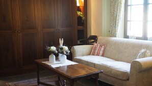 A living room with a wooden coffee table, a beige sofa, and a large wooden wardrobe.