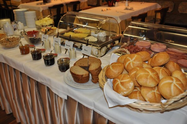 Una mesa de buffet con diversos alimentos y salsas.